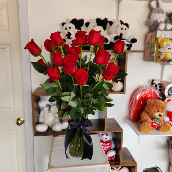 Bouquet of red roses in a glass vase with a black ribbon