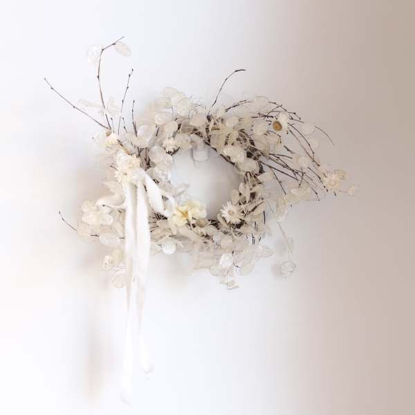 White floral wreath with delicate branches and hanging ribbon