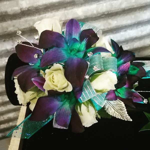 Bouquet of white roses with purple and teal orchid-like flowers and ribbon