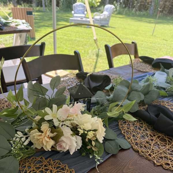 Low floral centerpiece with cream and blush flowers on a table