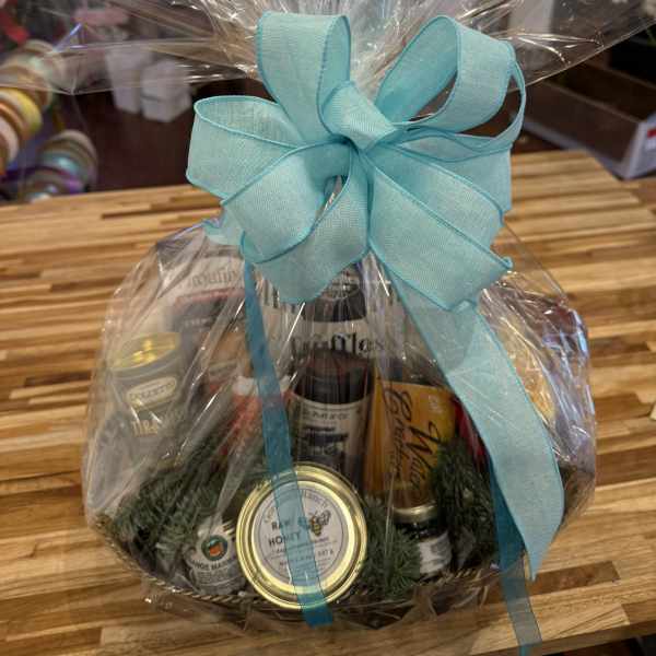 Gift basket wrapped in clear cellophane with a turquoise bow