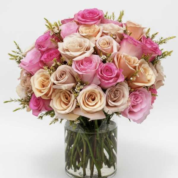 Bouquet of pink and peach roses in a clear glass vase