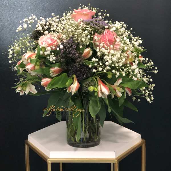 Pink roses and white alstroemeria in a glass vase