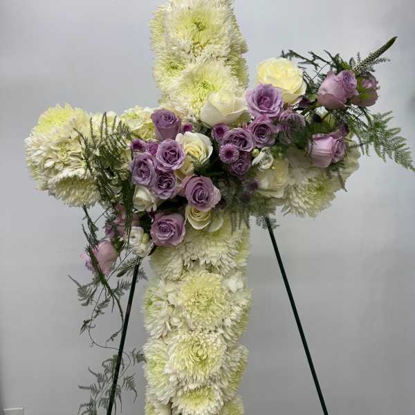 Cross-shaped floral tribute with white chrysanthemums and lavender roses