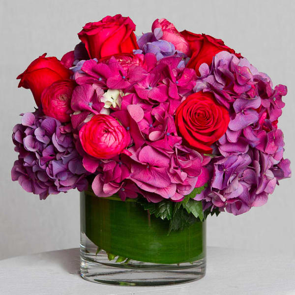 Pink and purple flower arrangement in a clear glass vase