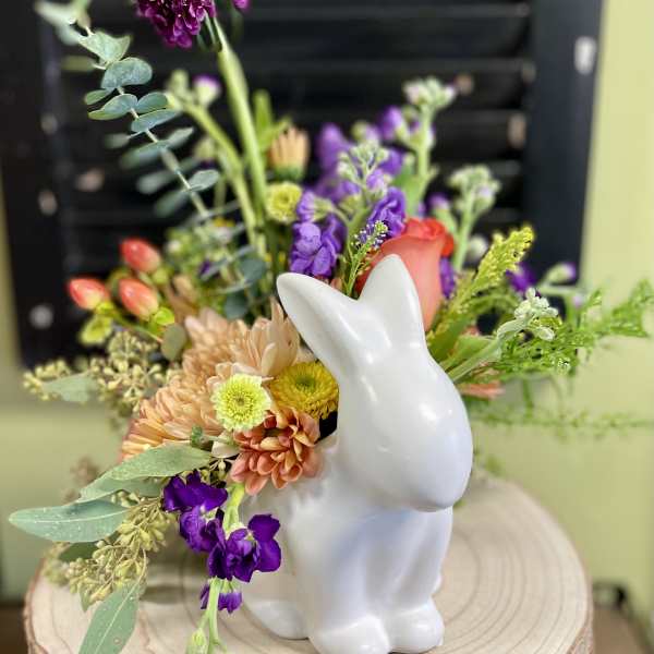 Mixed flower arrangement in a white rabbit vase