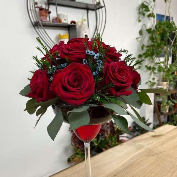 Red roses arranged in a wine glass vase