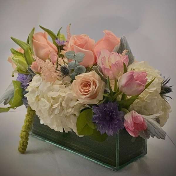 Pastel flower arrangement in a rectangular glass vase