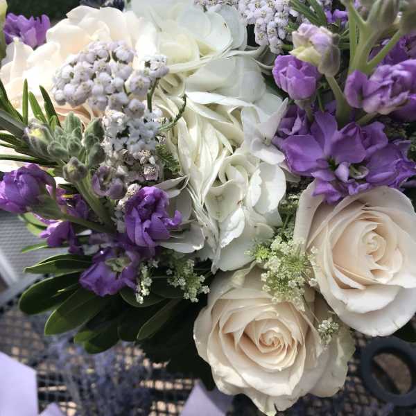 Bouquet of white roses, hydrangea, and purple flowers
