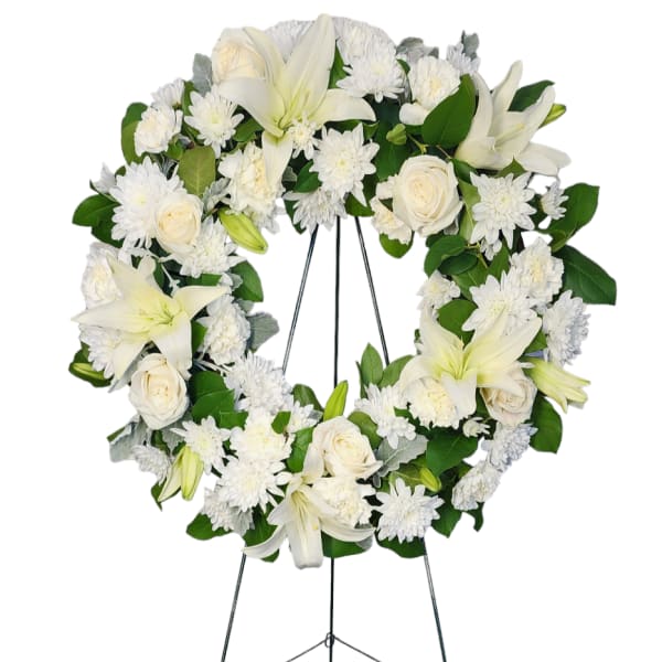 White floral wreath on a metal easel stand