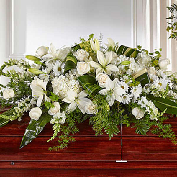 White floral casket spray with lilies and roses
