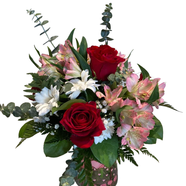 Bouquet of red roses, pink alstroemeria, and white daisies in a glass vase