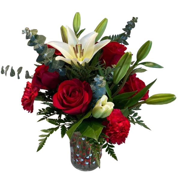 Red roses and white lilies in a heart-patterned glass vase