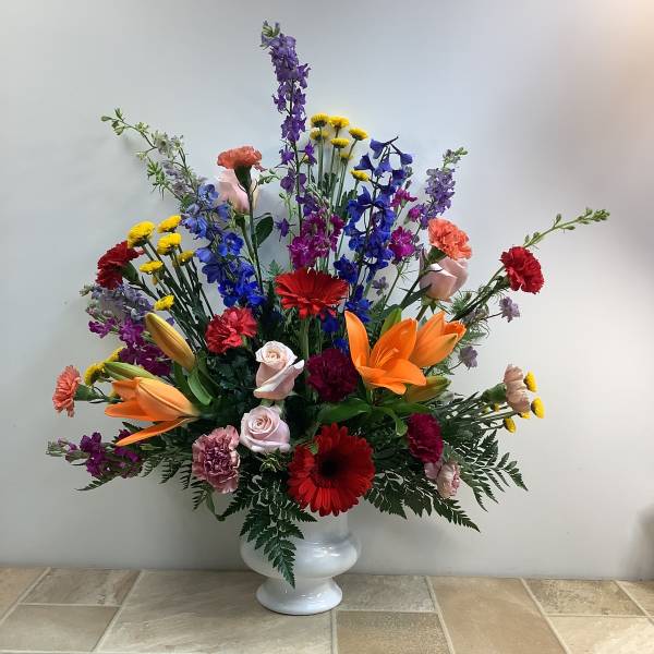 Colorful mixed flower arrangement in a white vase