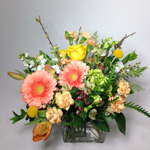 Mixed bouquet with pink gerbera daisies and yellow roses in a glass vase
