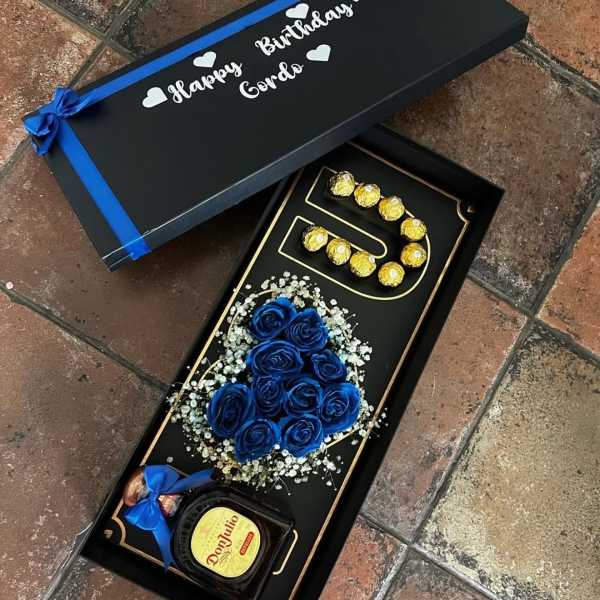 Gift box with blue roses, chocolates, and a bottle of Don Julio