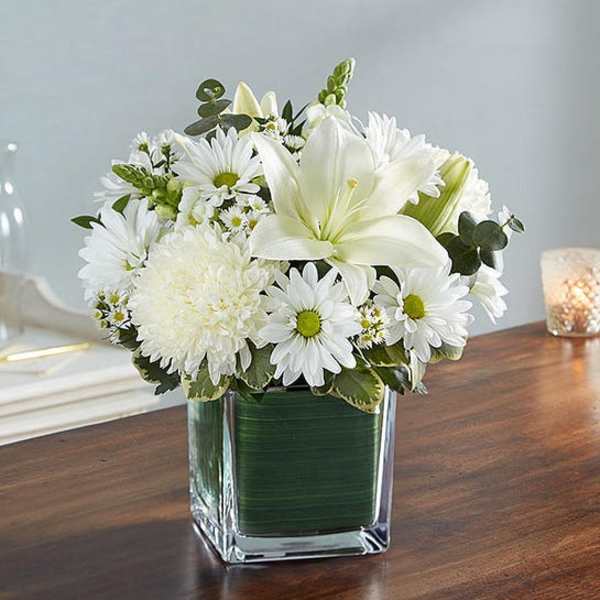 White flowers arranged in a square glass vase