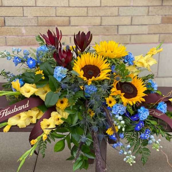 Bouquet with sunflowers, blue flowers, and yellow blooms tied with ribbons