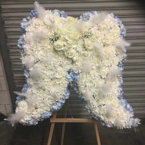 Large white floral standing spray on an easel with pale blue accents