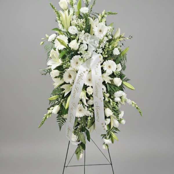 White sympathy standing spray on an easel with ribbon