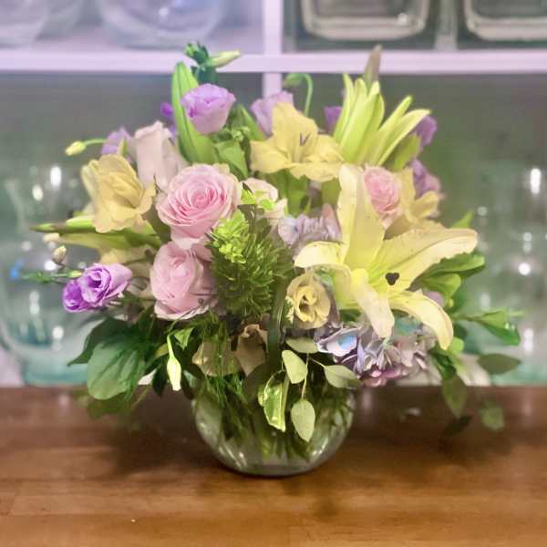 Mixed pastel bouquet in a glass vase with lilies and roses