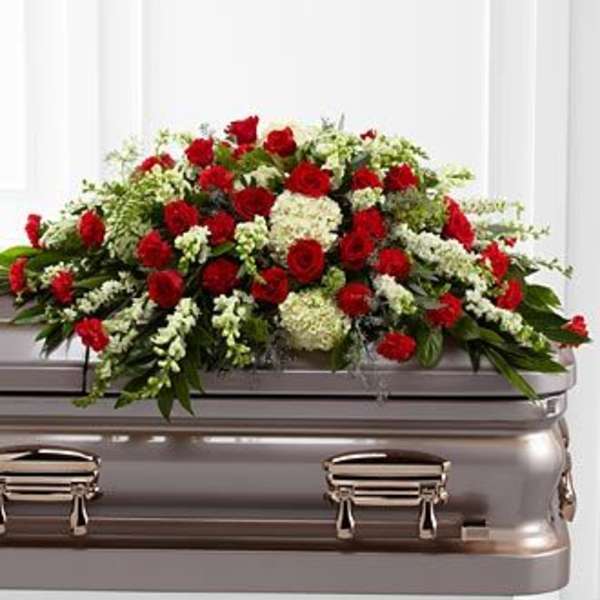 Red roses and white flowers arranged on a casket