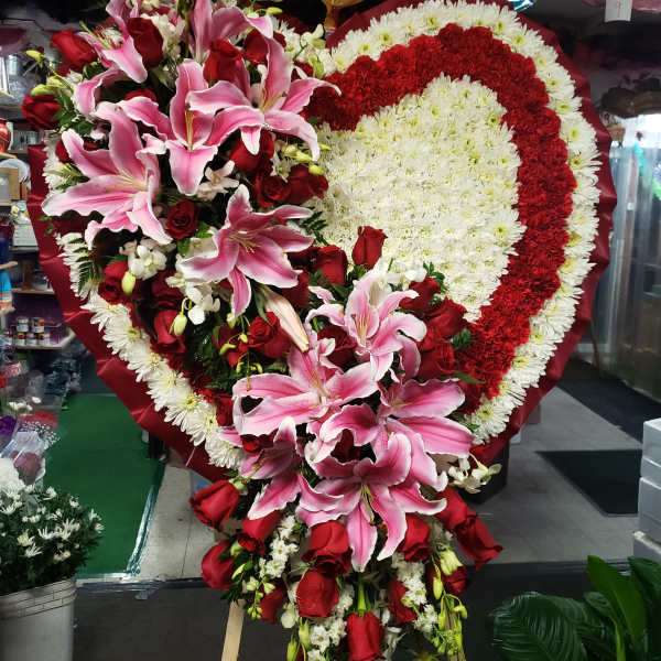 Heart-shaped floral spray with pink lilies and red roses