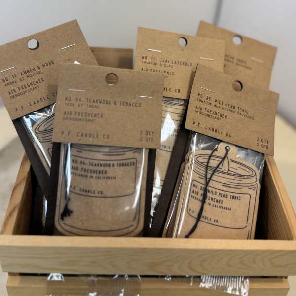 Assorted air freshener packets in a wooden tray