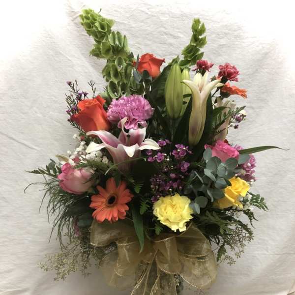 Mixed bouquet in a glass vase with lilies, roses, and gerbera daisies