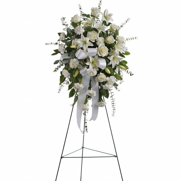 White floral standing spray on an easel with ribbon