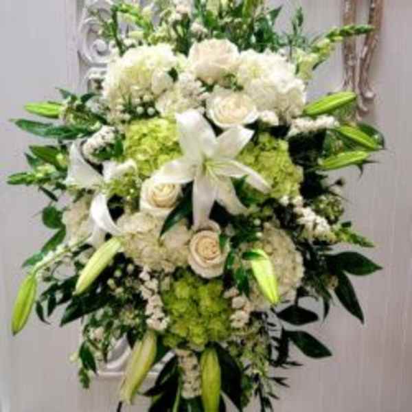 Large white and green floral standing spray with lilies and roses