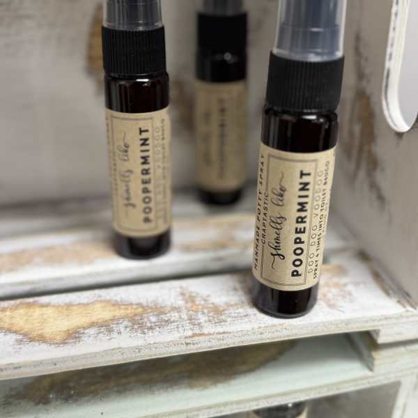 Three small spray bottles labeled peppermint sit on a shelf.