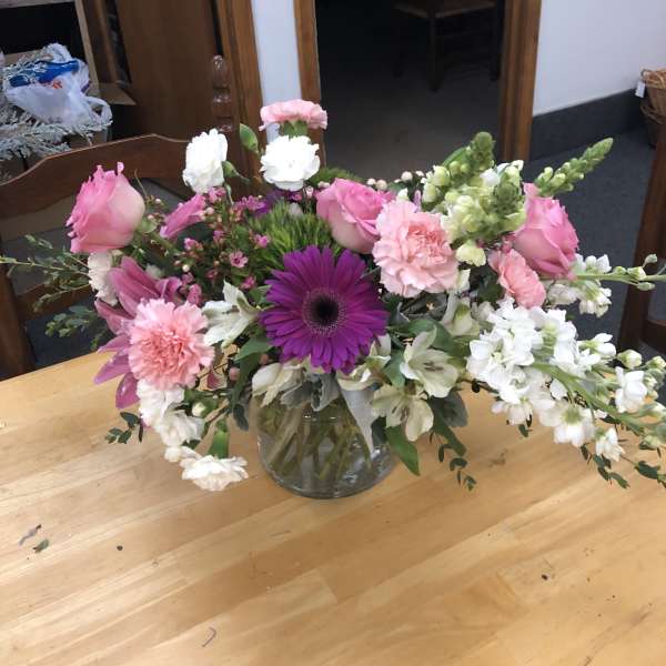 Pink and white mixed flower arrangement in a clear glass vase