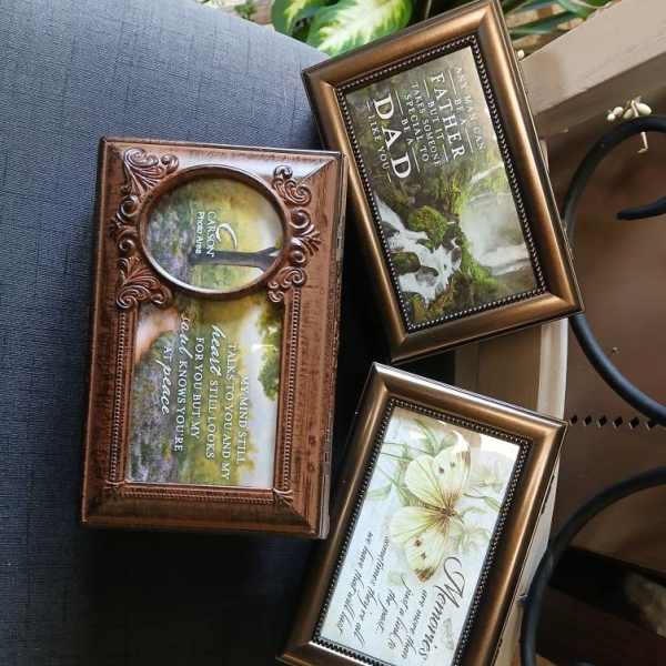 Three framed memorial plaques with floral designs and quotes
