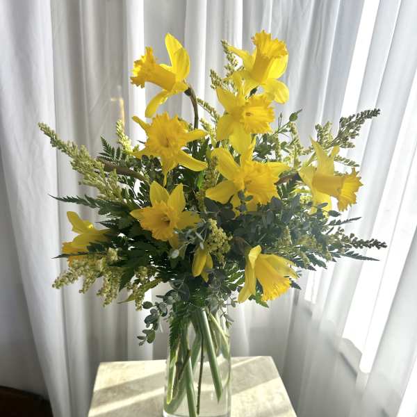 Yellow daffodil bouquet in a clear glass vase