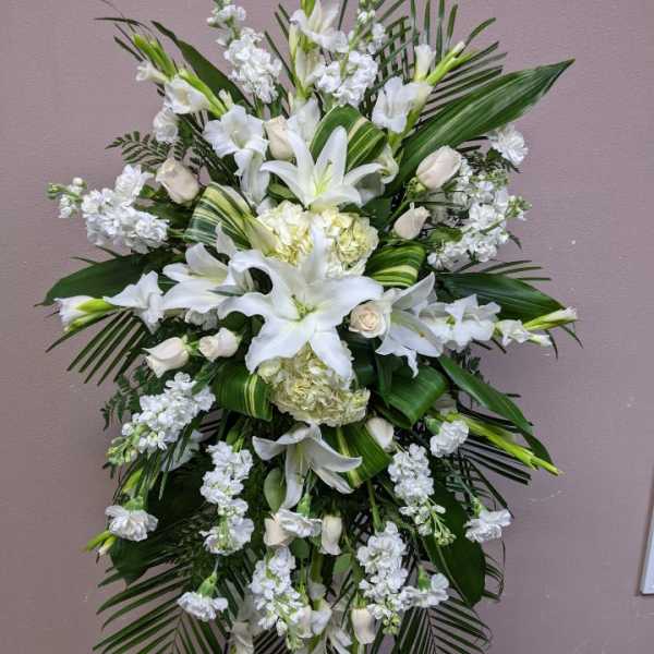 Tall white floral standing spray with lilies and roses