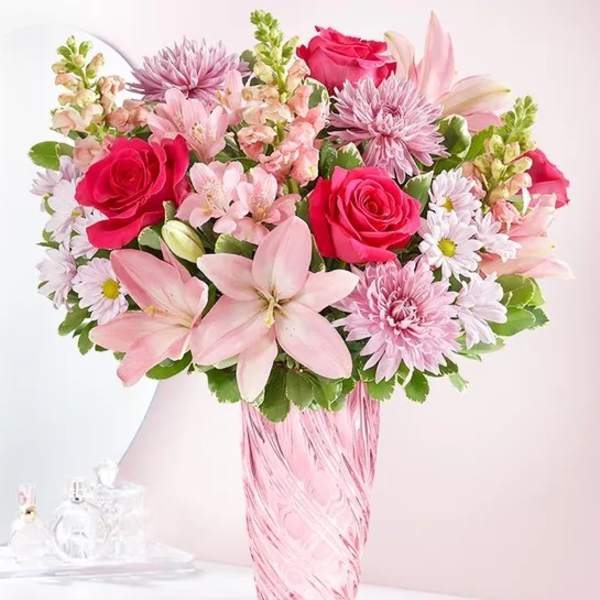 Pink mixed bouquet in a tall pink glass vase