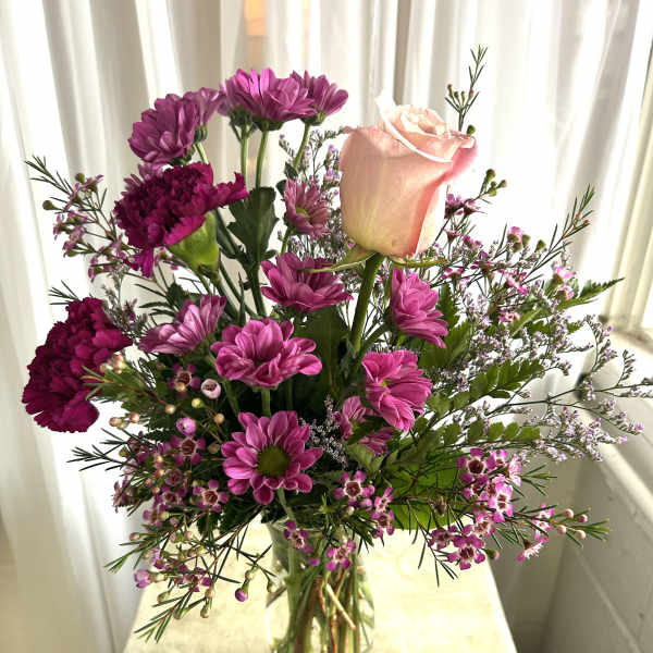 Pink and purple mixed bouquet in a clear glass vase