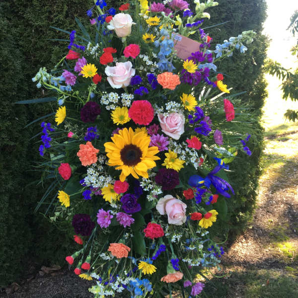 Large standing spray with multicolored flowers on a black easel