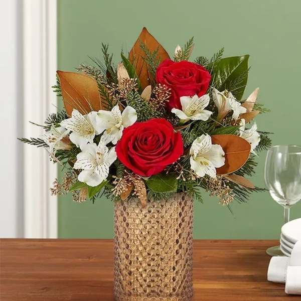Red roses and white flowers arranged in a textured vase