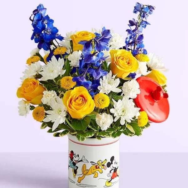 Bouquet of yellow, white, and blue flowers in a Mickey Mouse tin