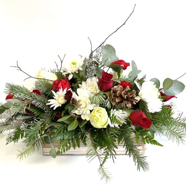 Holiday floral arrangement in a wooden box with red and white blooms