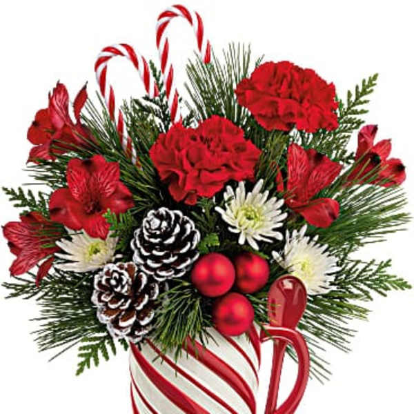Christmas bouquet in a candy cane mug with red flowers and pinecones