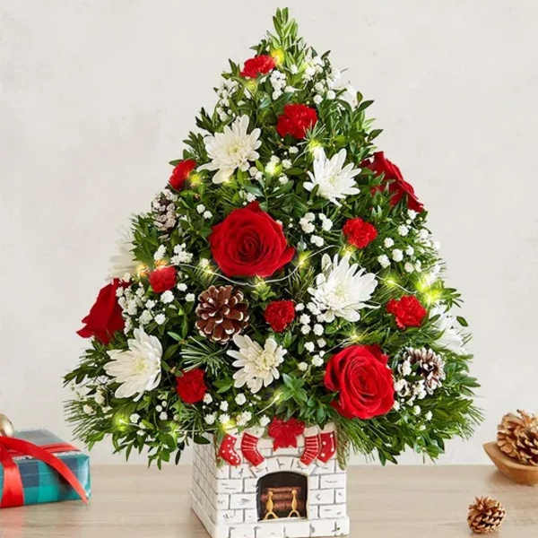 Christmas tree-shaped floral arrangement with red and white flowers in a decorative vase