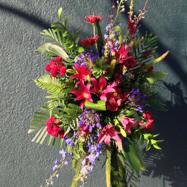 Bright tropical floral spray with pink lilies and purple accents
