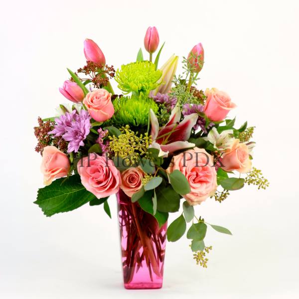 Pink and peach mixed bouquet in a tall pink vase