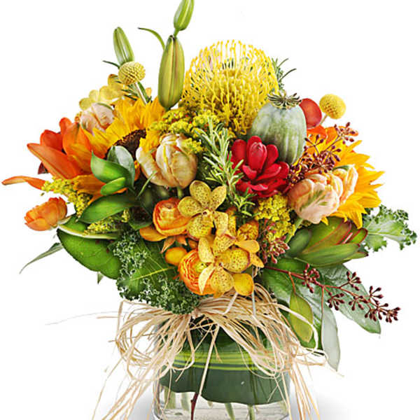 Colorful bouquet in a clear glass vase with sunflowers and lilies