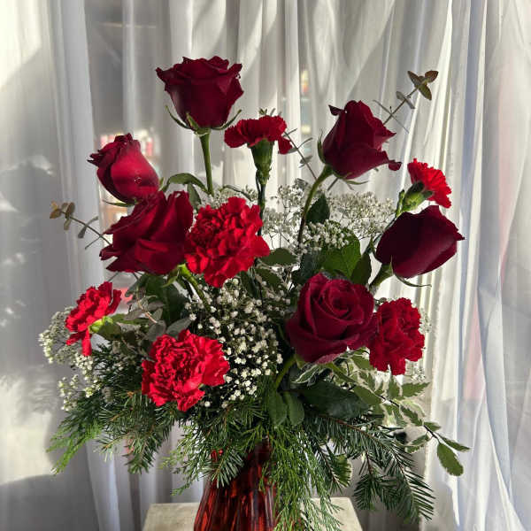 Red roses and carnations in a red glass vase