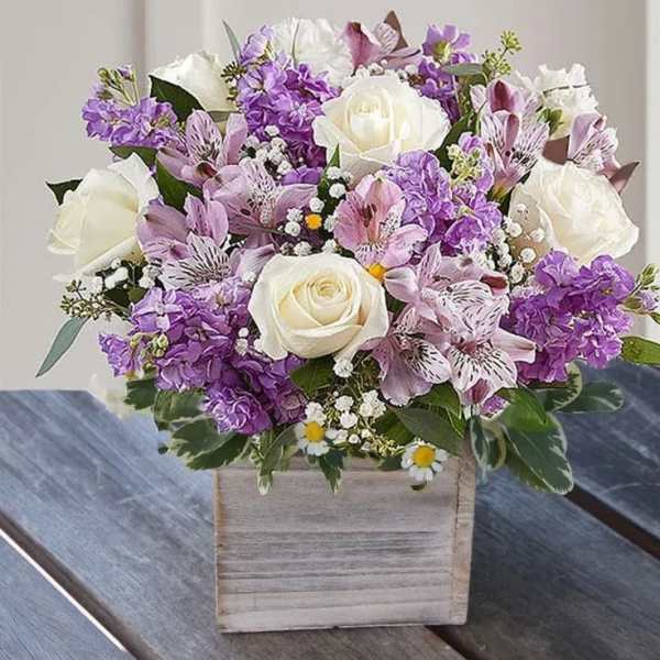 Purple and white floral arrangement in a wooden box
