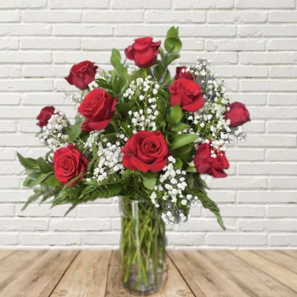Red roses and white baby's breath in a clear glass vase